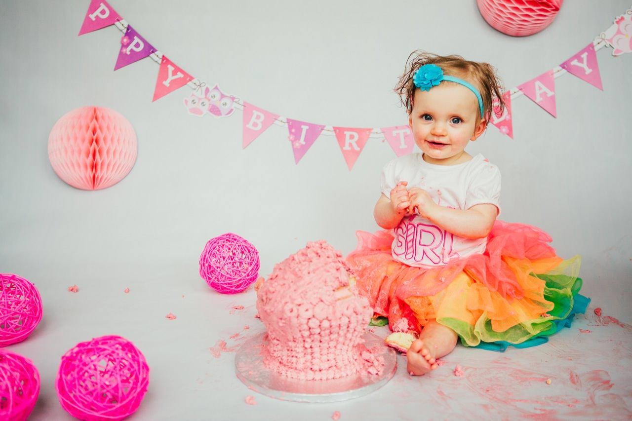 Cakesmash Fotoshooting Kinder isst den Kuchen zum ersten Geburtstag Fotoshooting